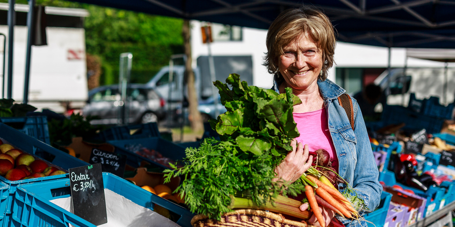 Biomarkt | vrouw met verse groenten Biomarkt | vrouw met verse groenten